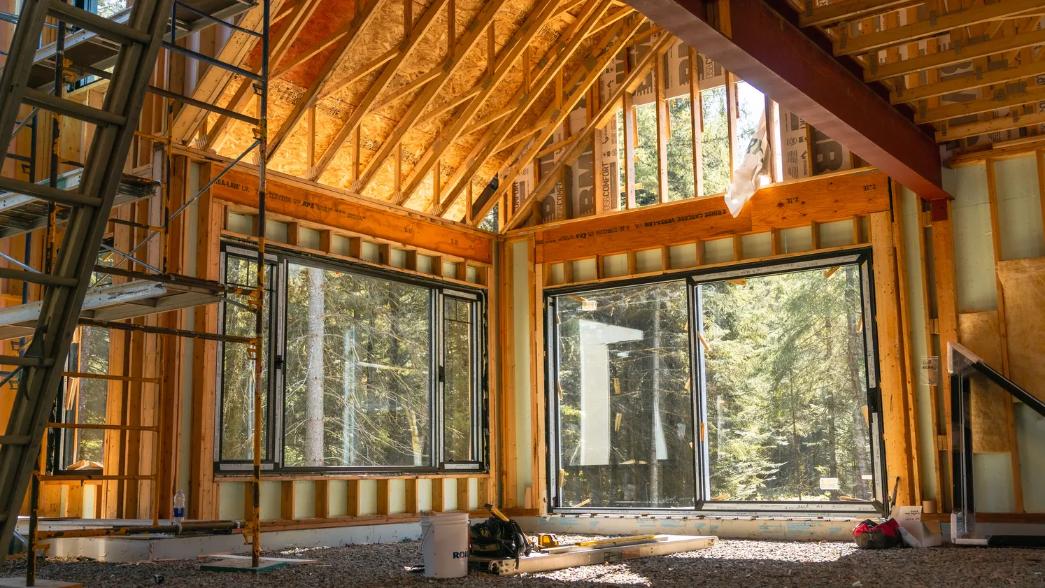 Portes vitrées et fenêtres dans une pièce à plafond cathédrale en bois.