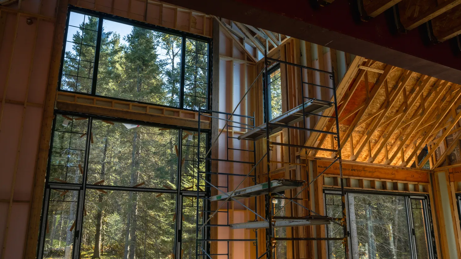 Mur de grandes fenêtres dans une maison à structure de bois.