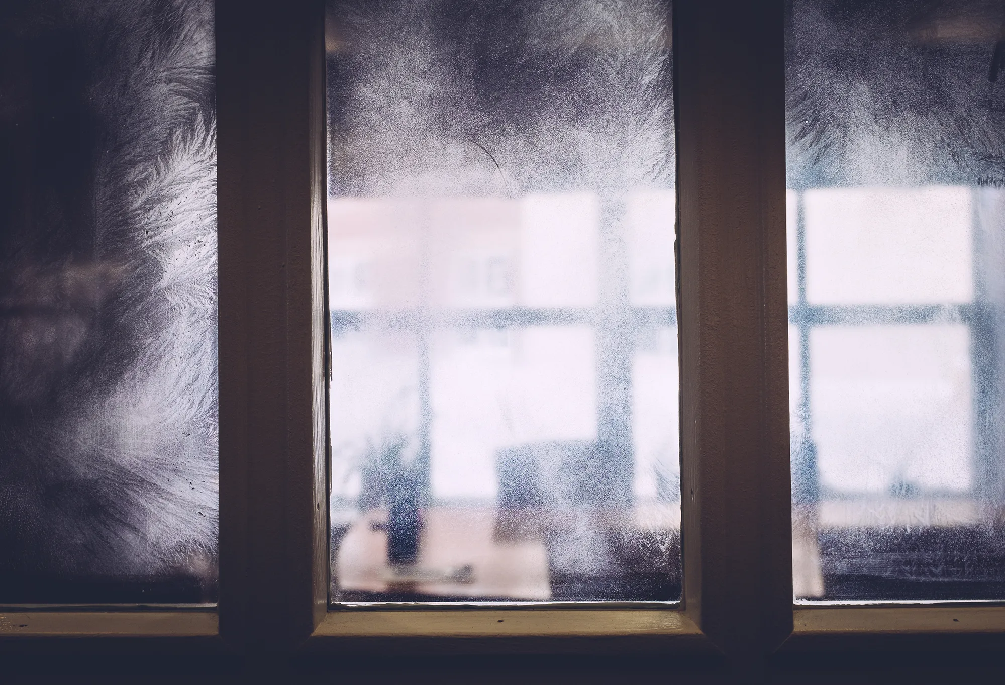 Fenêtres dont les vitres sont couvertes de givre.