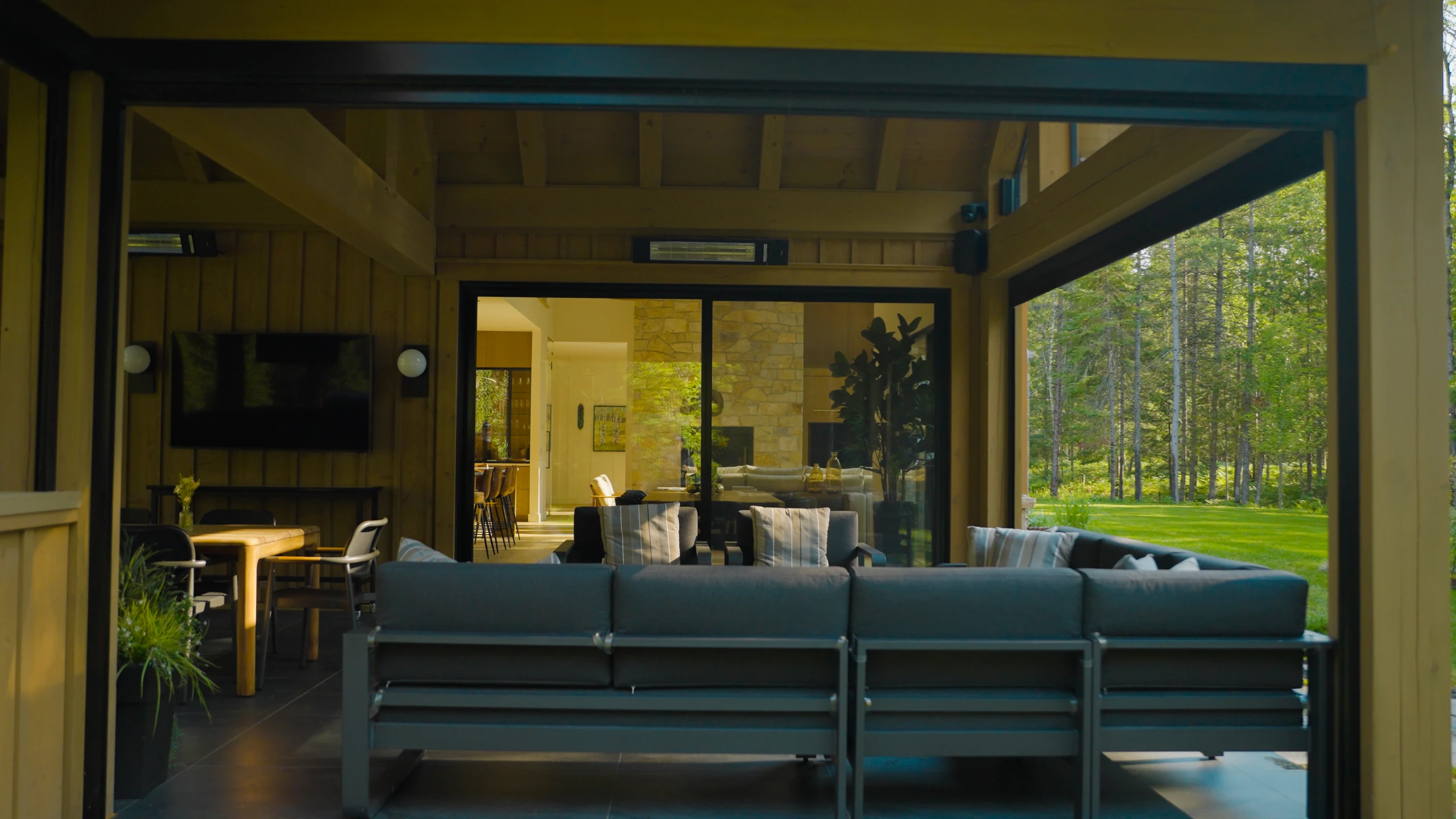 Grande porte patio vitrée donnant sur la terrasse couverte d’un chalet.