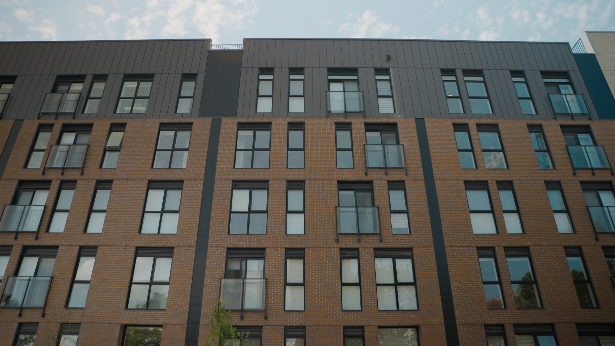 Façade d’un immeuble de plusieurs étages avec de grandes fenêtres verticales.